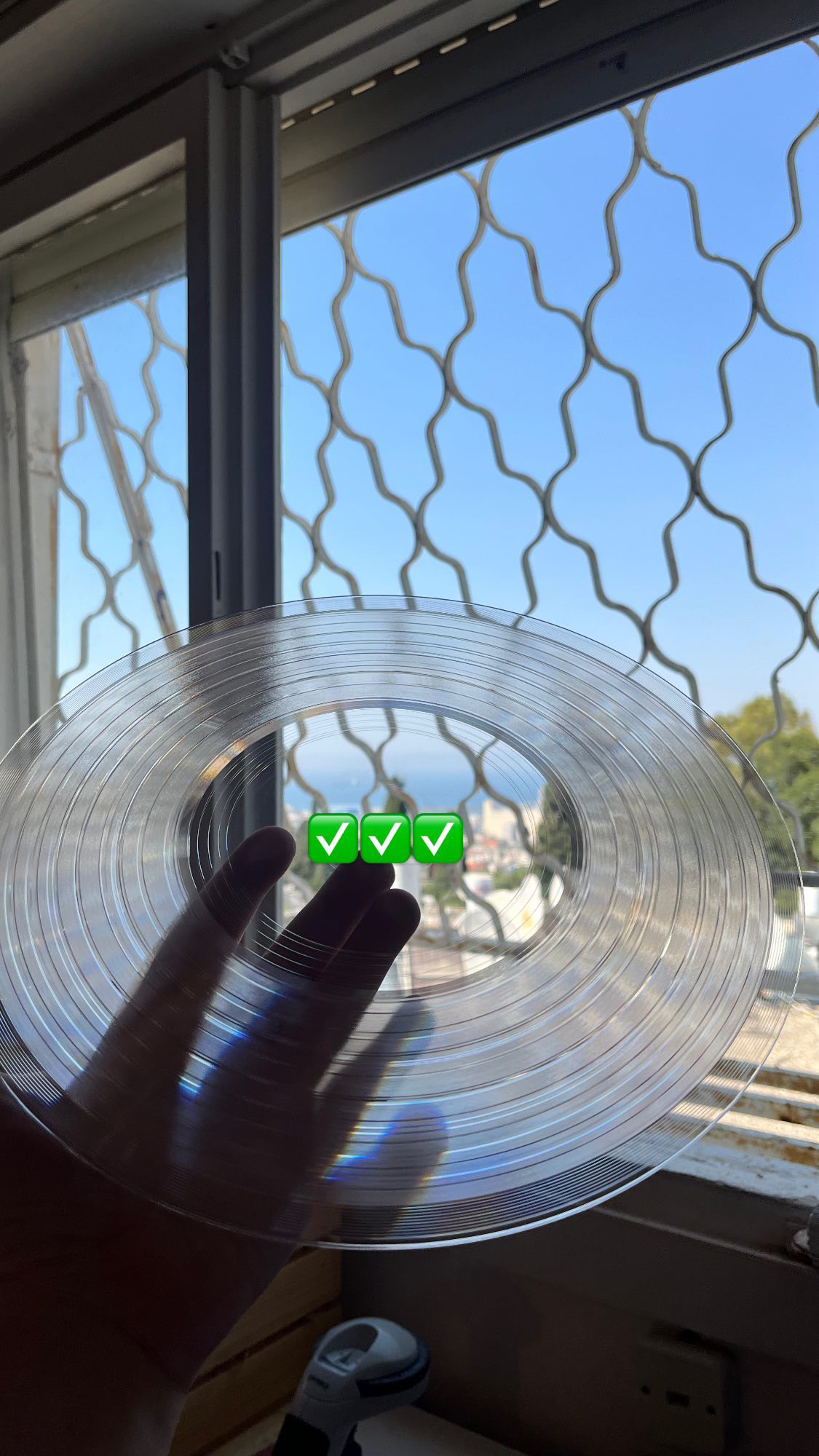 Transparent vinyl held up against a Haifa window view