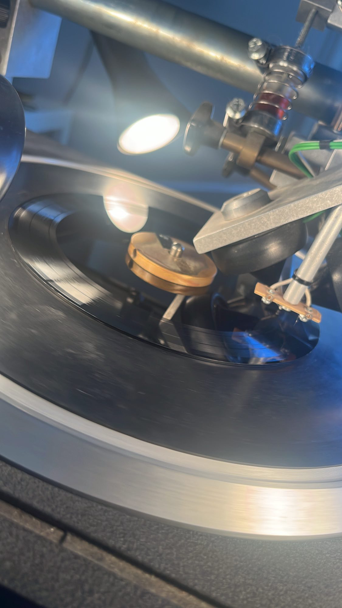 Black vinyl spinning on the lathe with sunlight in the PLASTIK studio